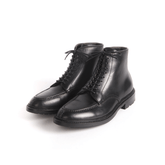 A pair of matte black Norwegian toe tanker boots made of cowhide with a lace-up closure.