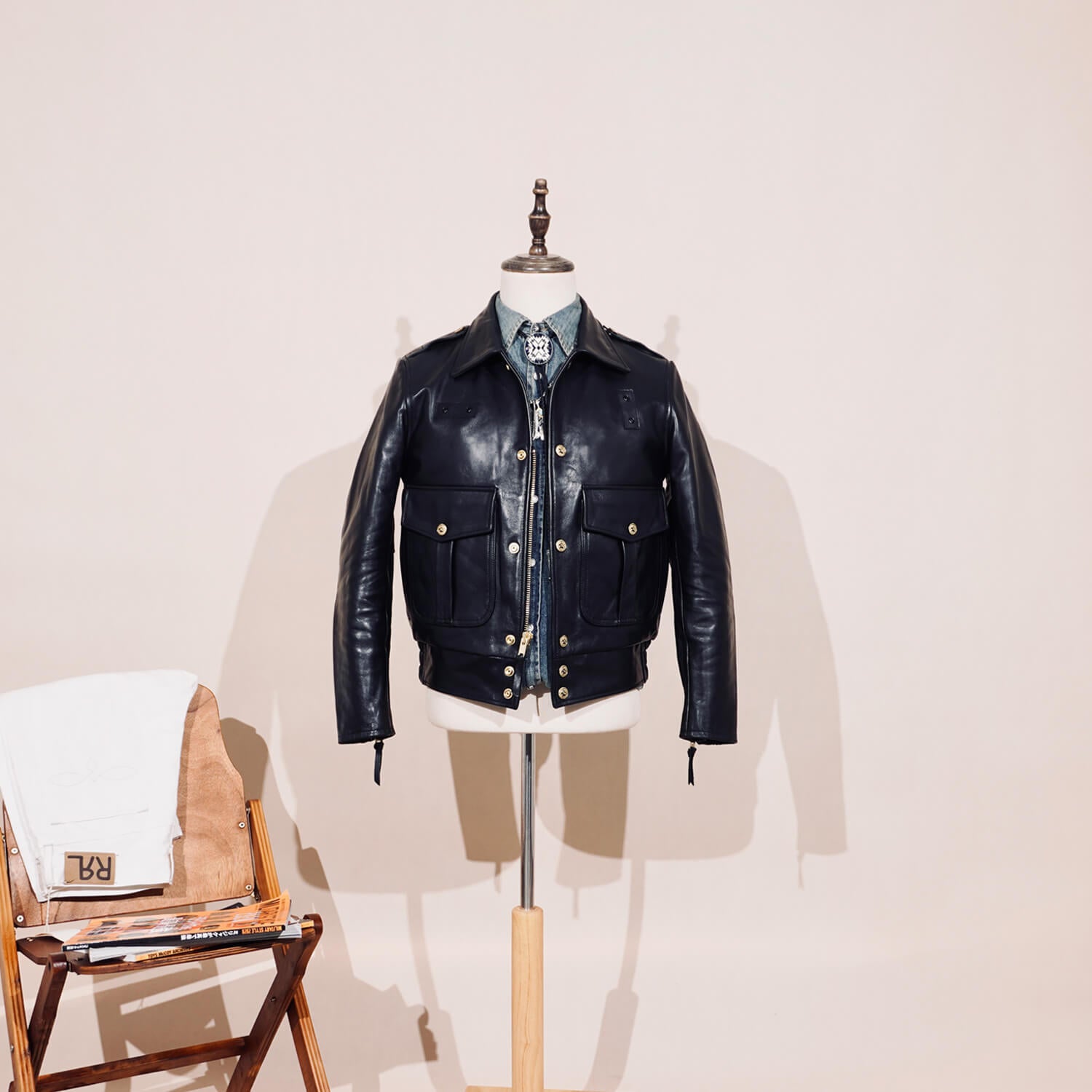 Black leather jacket on a mannequin against a plain background