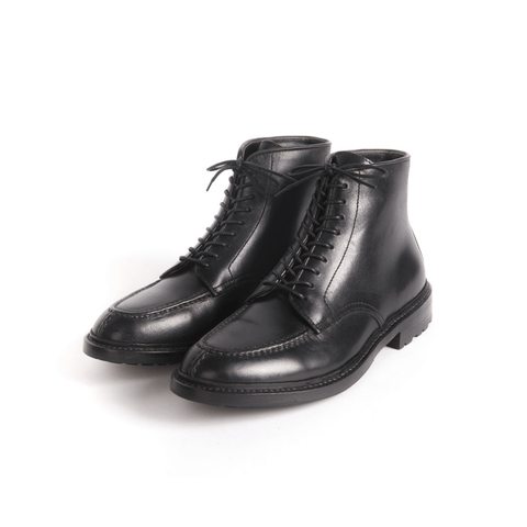 A pair of matte black Norwegian toe tanker boots made of cowhide with a lace-up closure.